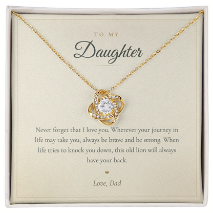 Hand holding the This Old Lion Has Your Back message card with love knot necklace
