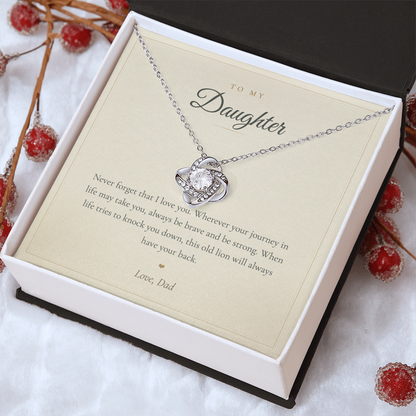 Hand holding the mahogany gift box with the daughter love knot necklace outdoors